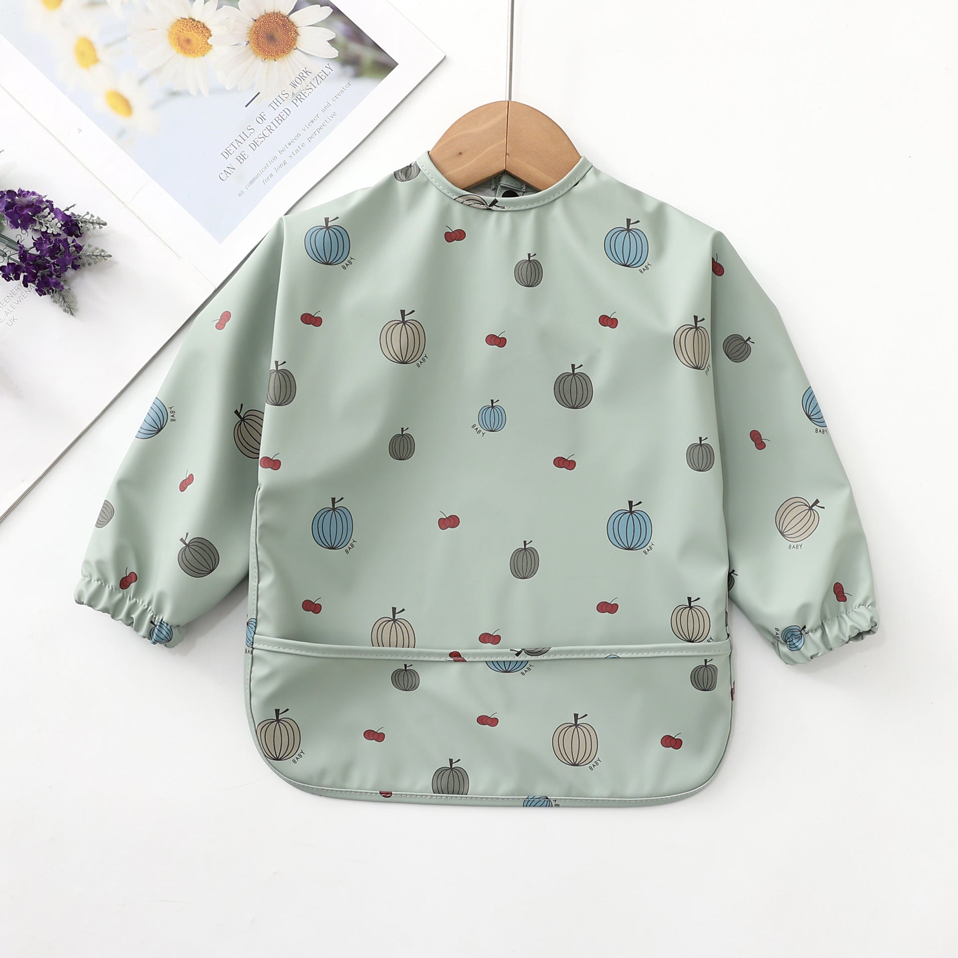 cute baby's apron bib with green pumpkins printed on a lime green background