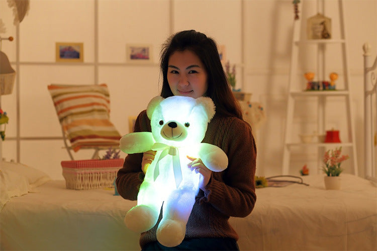 a girl is happy with a light up yellow bear