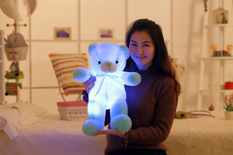 a girl charmingly holds a darling light up blue teddy bear