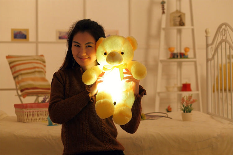 a girl carries a light up gold teddy bear