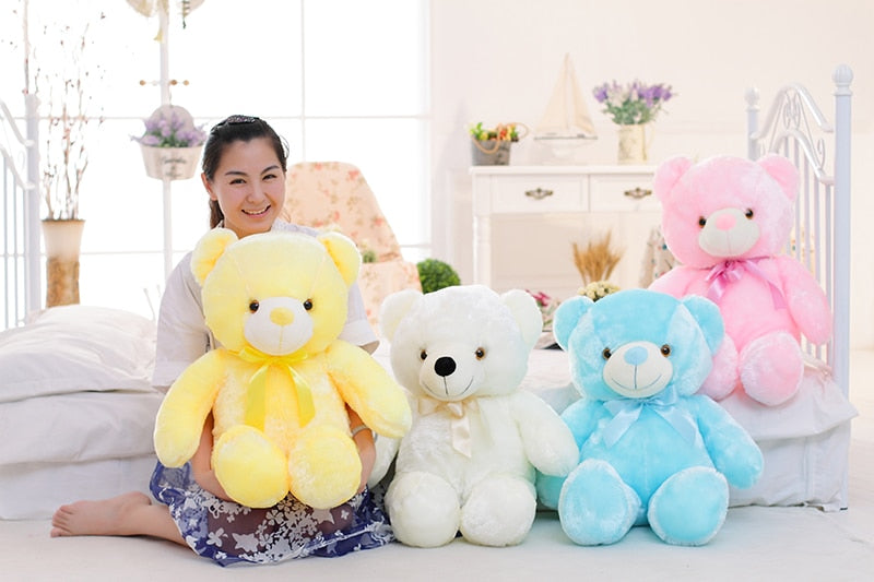 a girl smiles with four light up LED teddy bears 