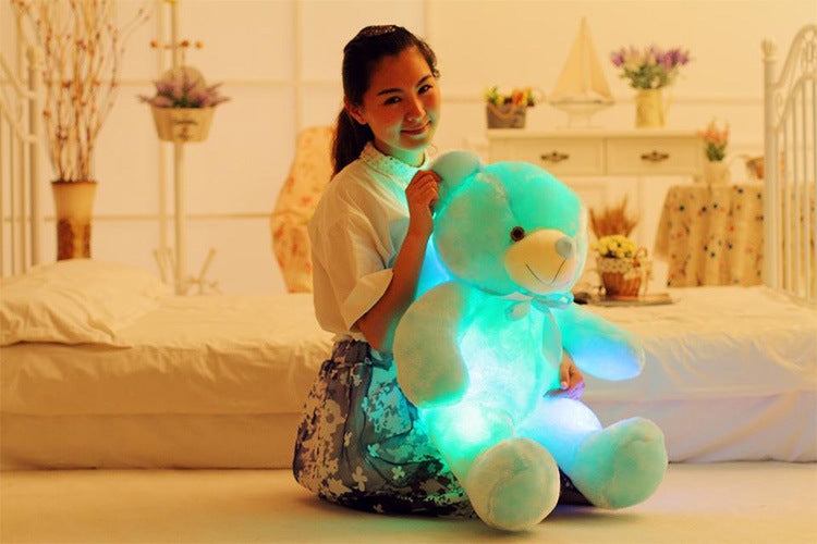 a girl holds a adorable green light up bear