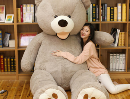 a girl sitting with a giant grey life-size bear