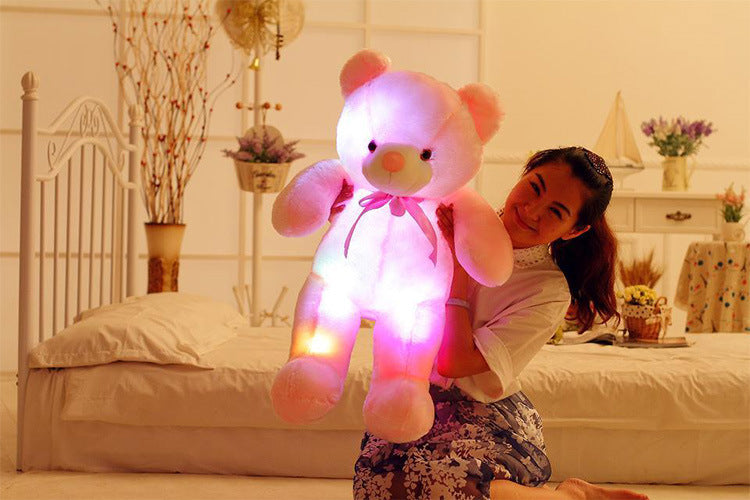 a girl is happy with a pink light up bear