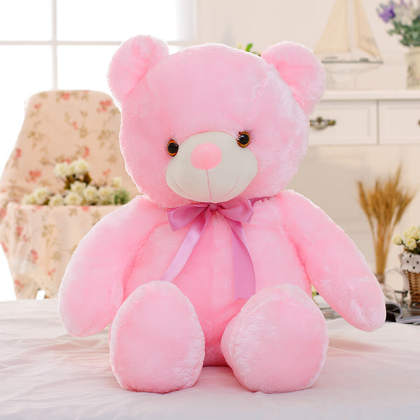 a adorable cute pink bear sits on a bed