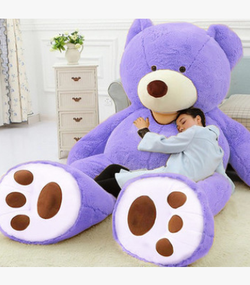 a boy sits with a giant purple teddy bear plush soft toy with leather shell 