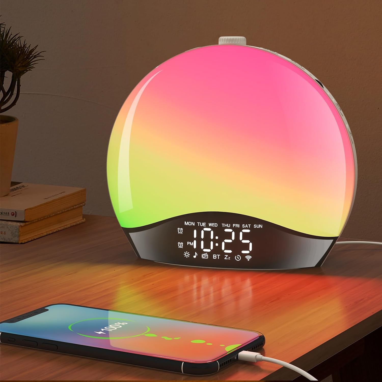 a sunrise light alarm clock laying on the bed with a phone in front of it. The clock displays time and warm light like a sunlight